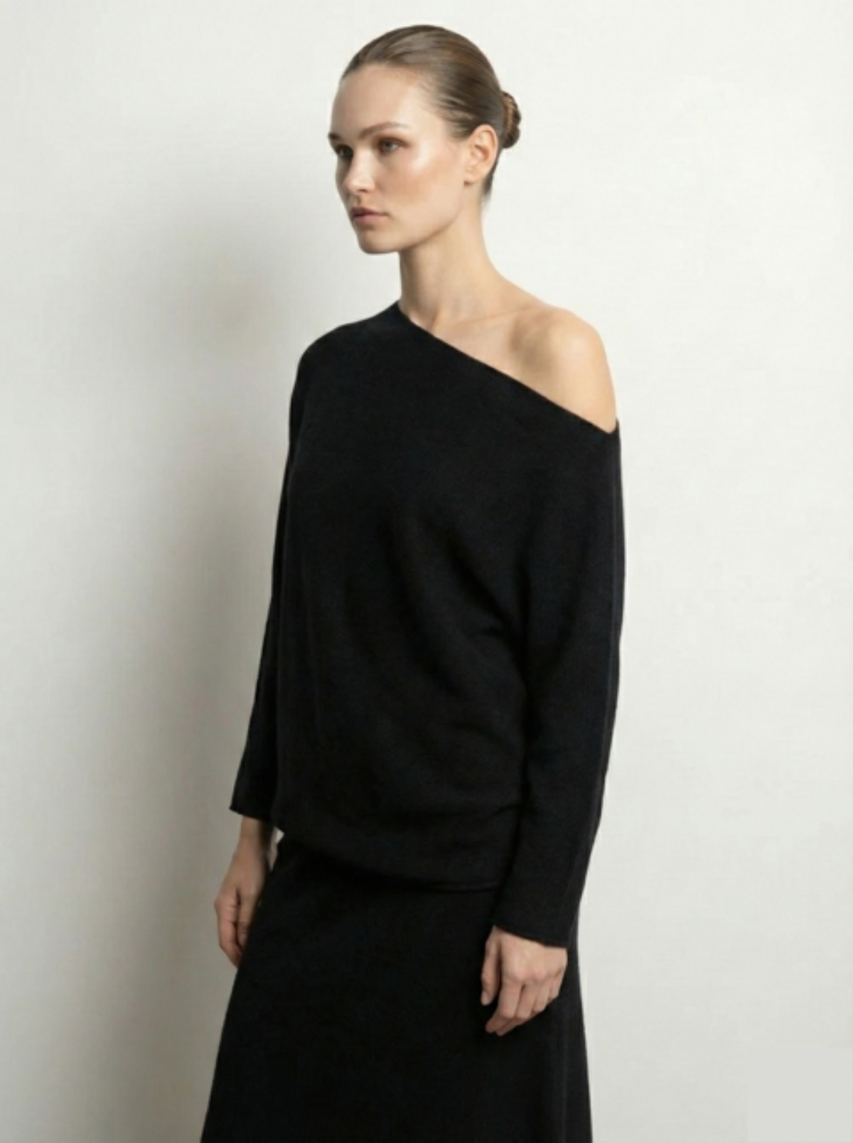 Woman wearing a black sweater against a plain background