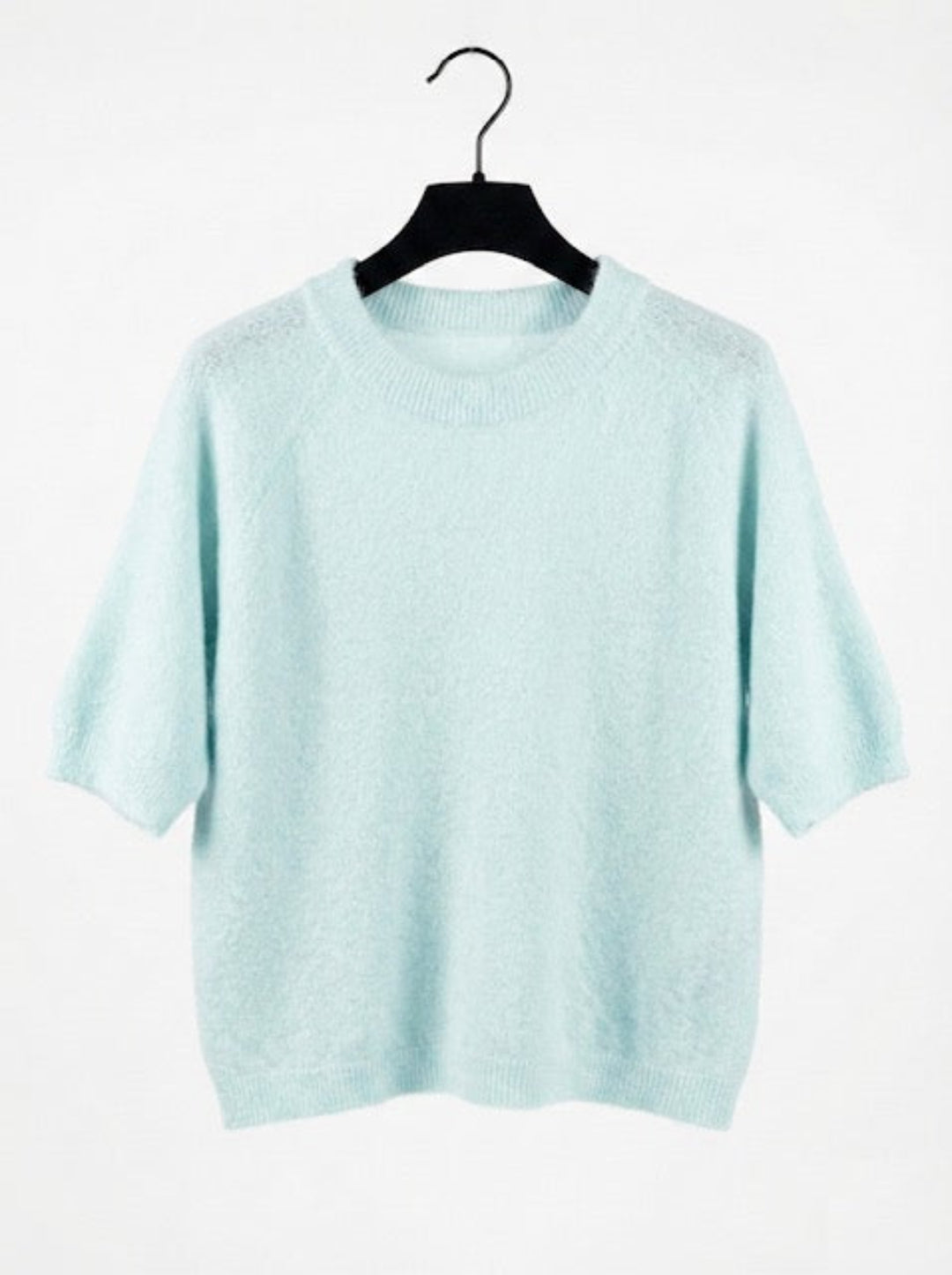 Light blue sweater on a hanger against a white background