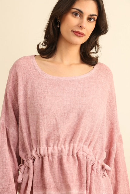 Woman wearing a pink dress against a beige background