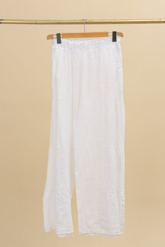 White pants hanging on a beige background