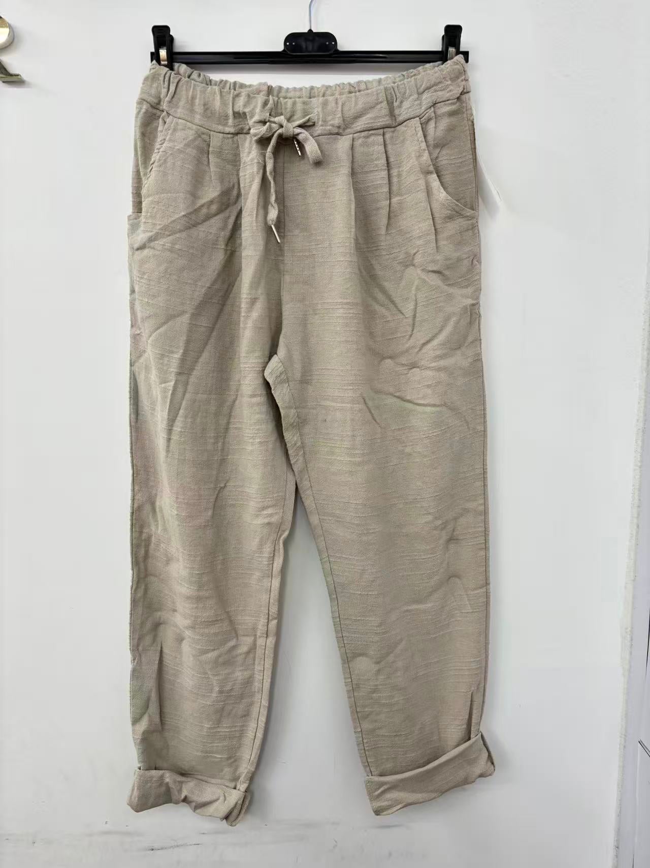 Beige pants on a hanger against a white background