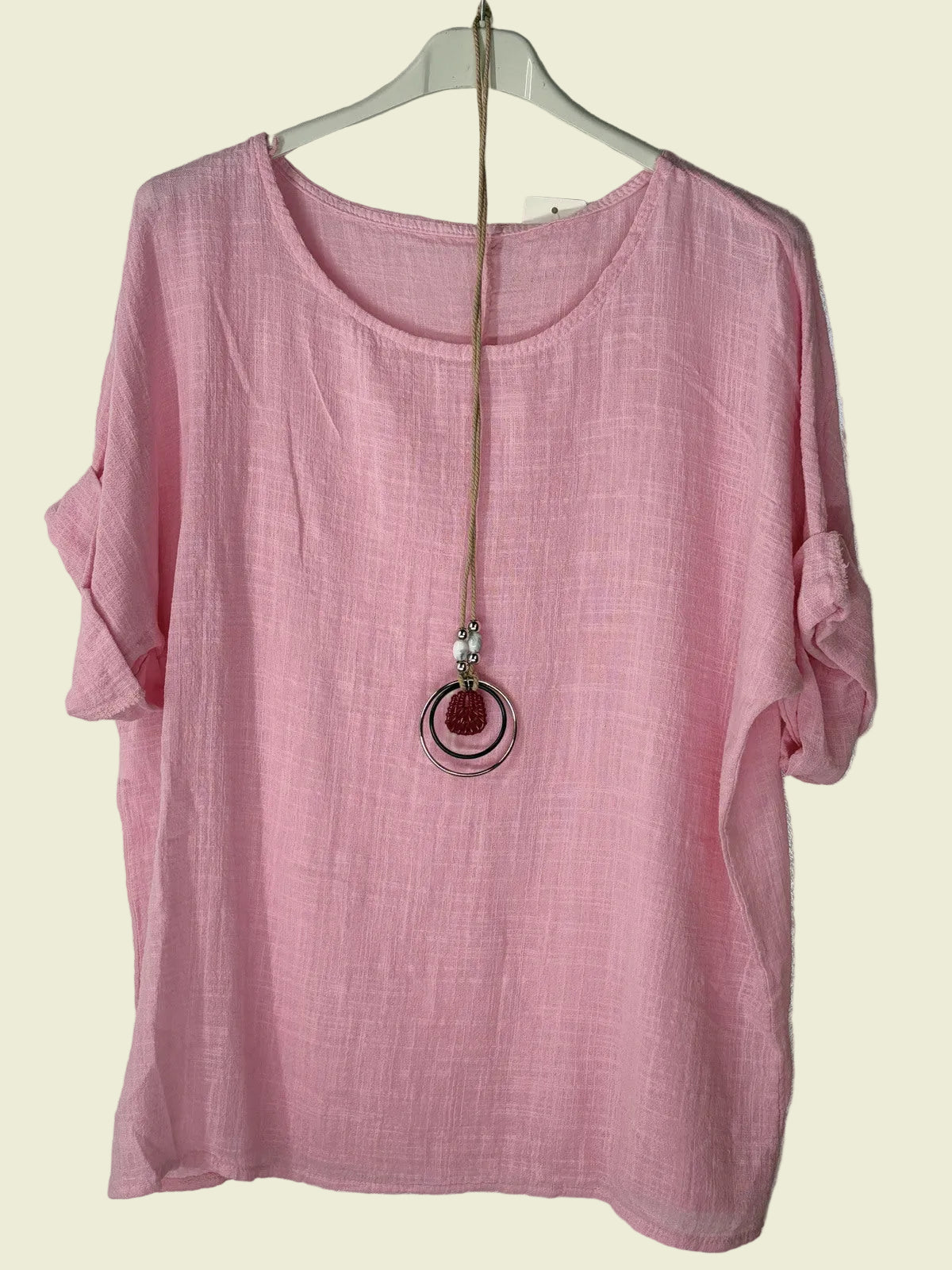 Pink top on a hanger with a necklace