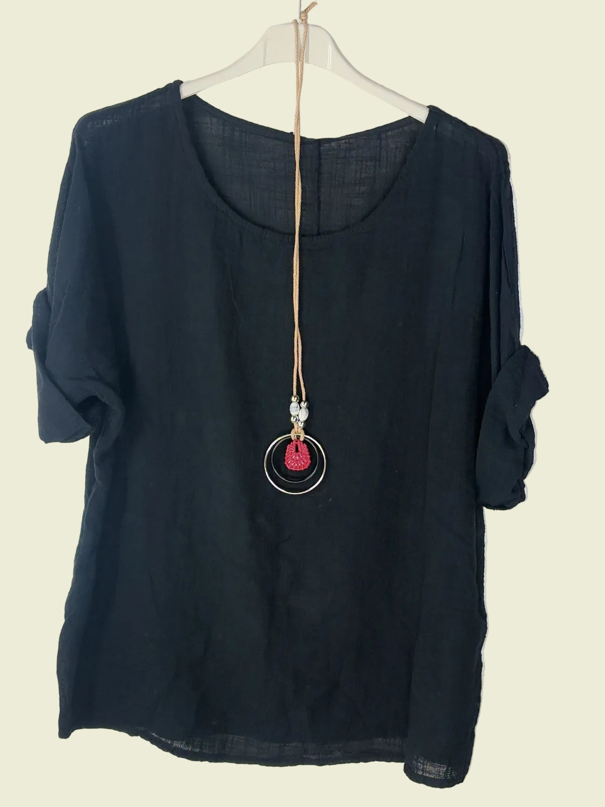 Black top with a necklace on a white background