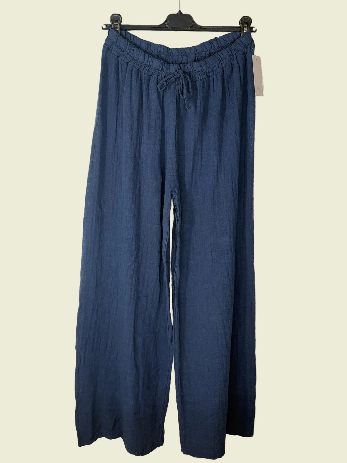 Blue pants hanging on a textured beige wall