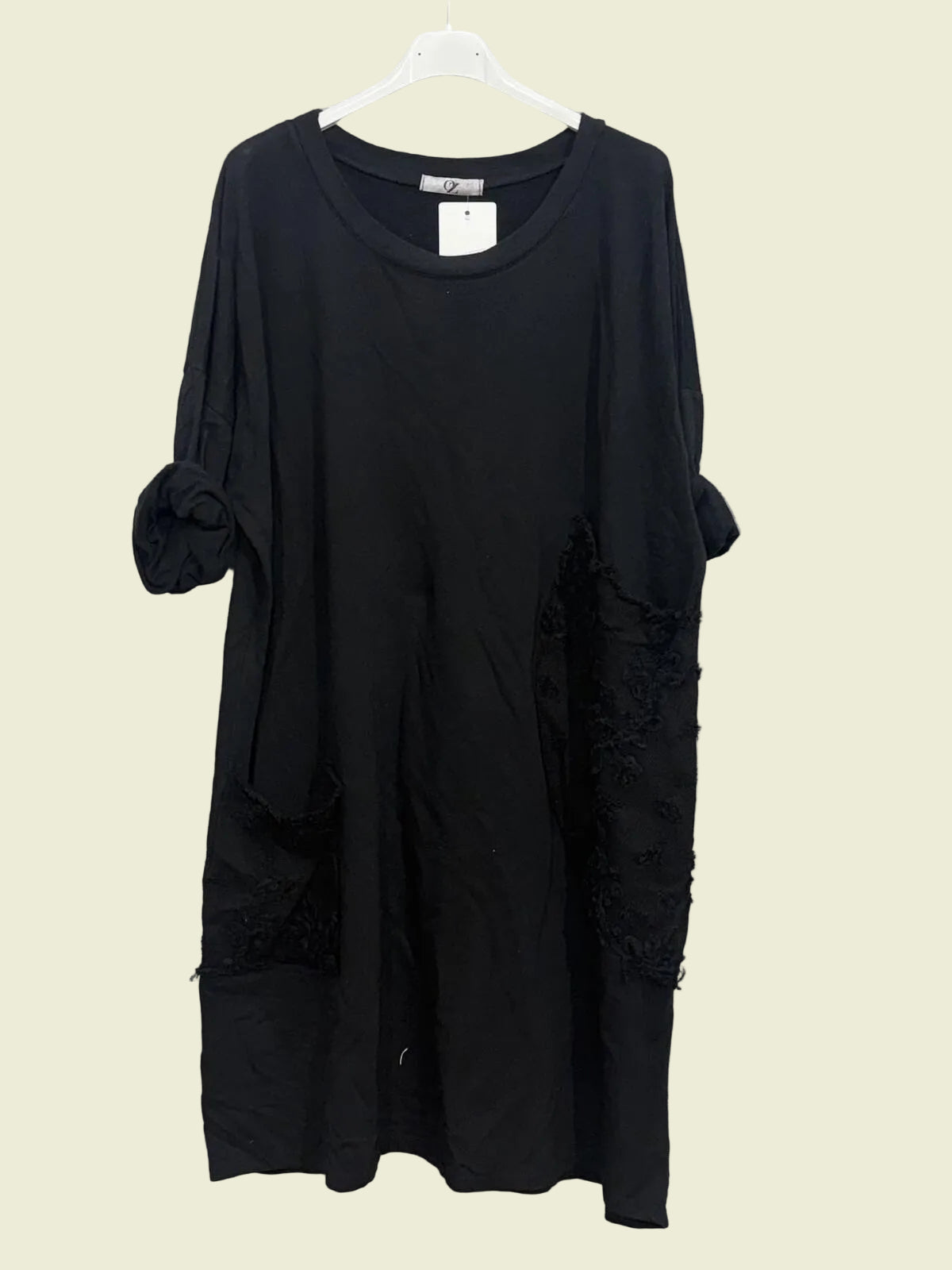 Black dress on a hanger with round neck and feature pockets