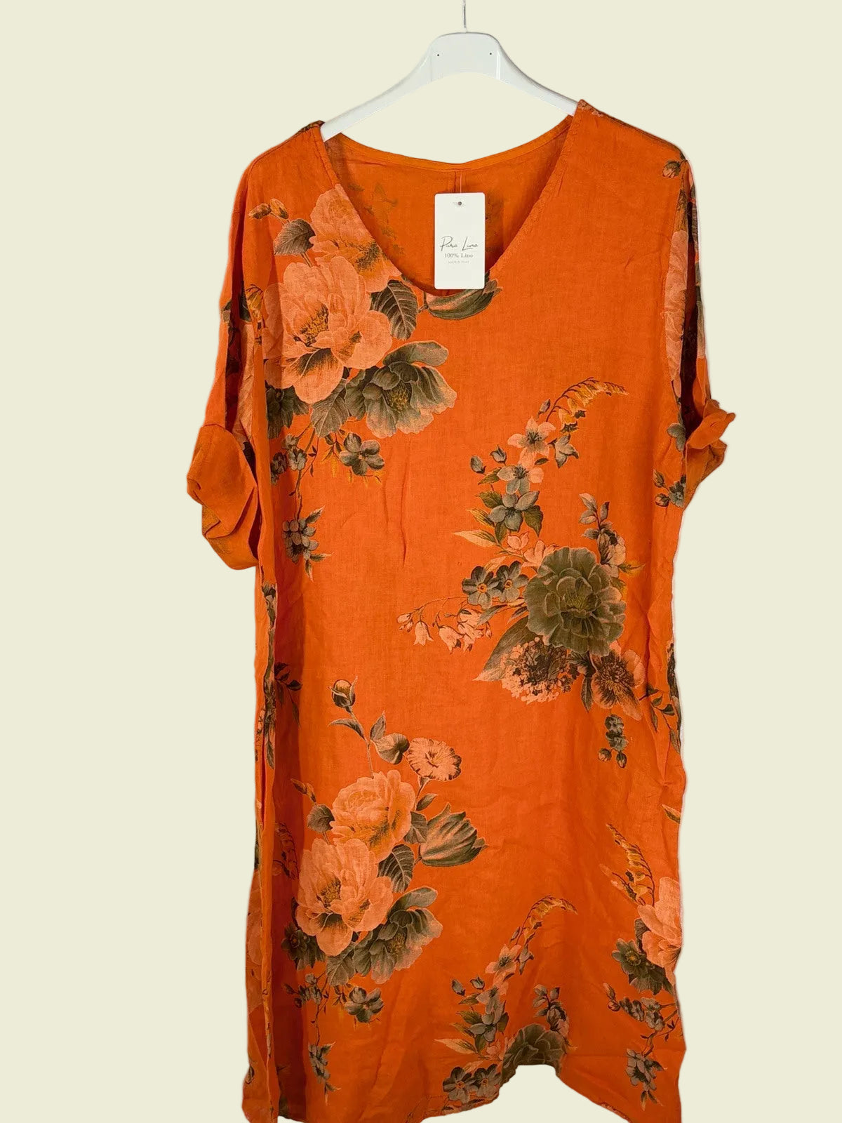 Orange floral dress on a white hanger