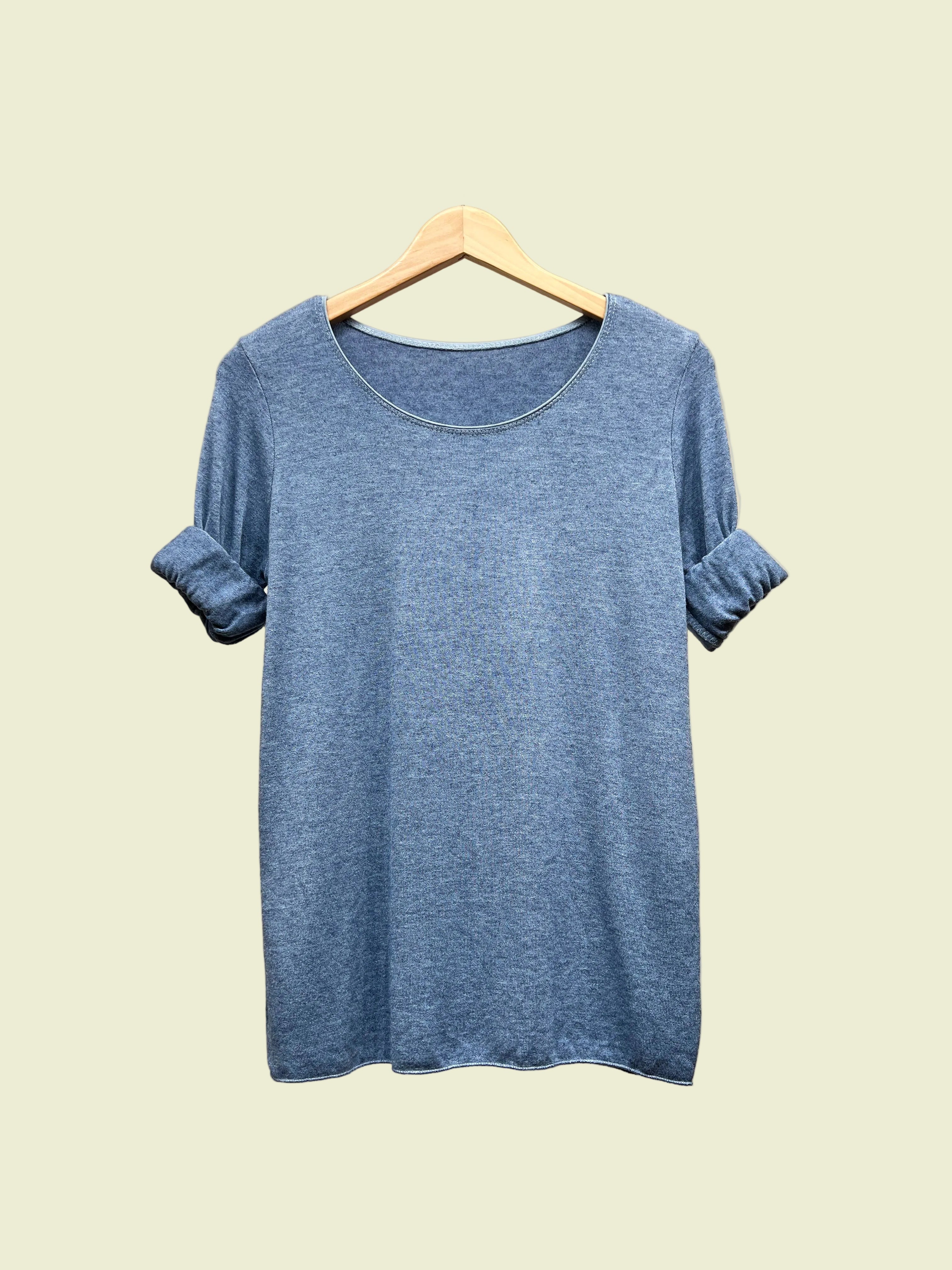 Blue t-shirt on a hanger against a neutral background
