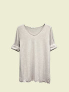 Light Grey t-shirt on a hanger against a neutral background