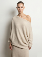 Woman wearing a beige asymmetric sweater