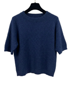 Blue sweater on a hanger against a white background