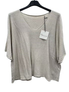 Beige top on a hanger with a visible brand tag against a white background