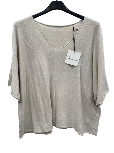 Beige top on a hanger with a visible brand tag against a white background