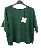 Green sweater on a hanger with a tag against a white background