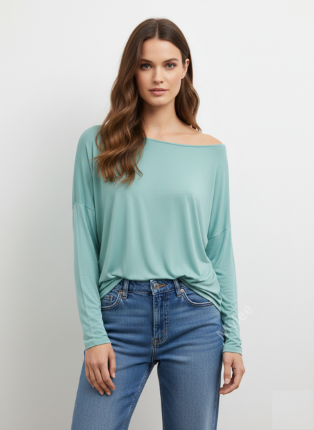 Woman wearing a light blue off-shoulder top and blue jeans on a white background