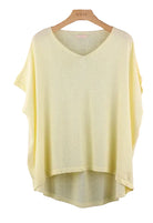 Light yellow sweater on a wooden hanger 