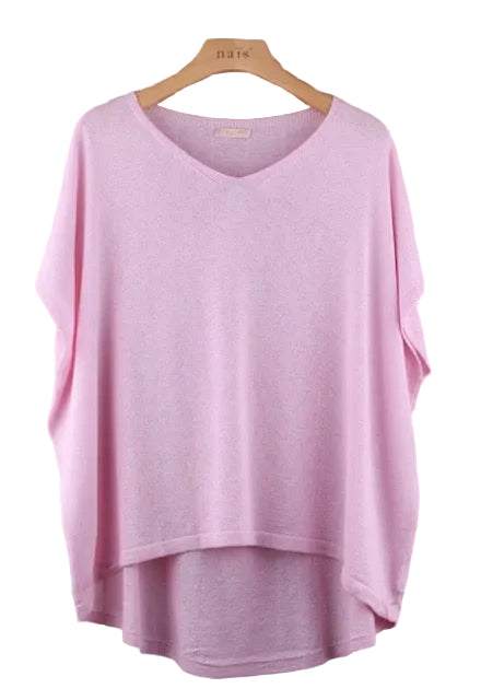 Pink top on a hanger against a tiled wall background