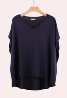 Navy blue sweater on a wooden hanger 
