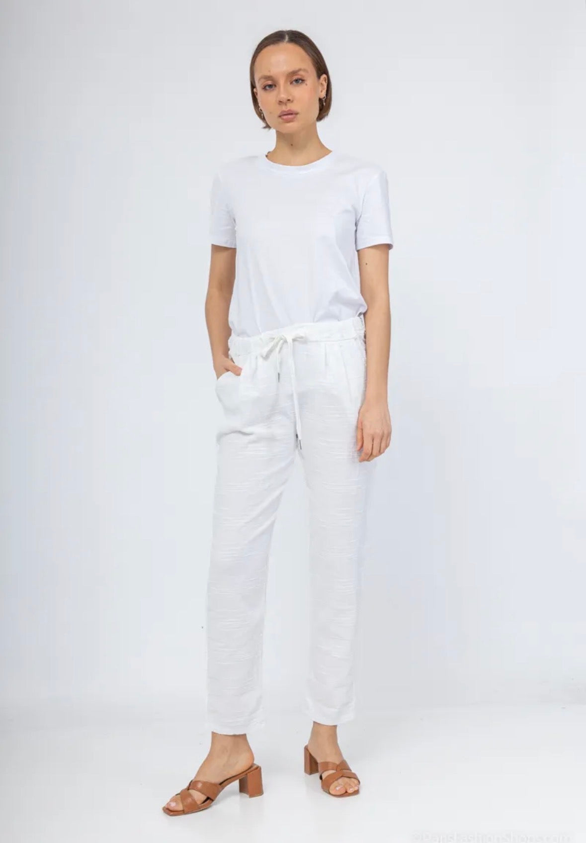 Woman wearing a white t-shirt and pants on a white background