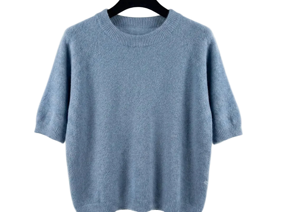 Light blue sweater on a hanger against a white background