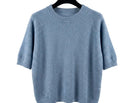 Light blue sweater on a hanger against a white background