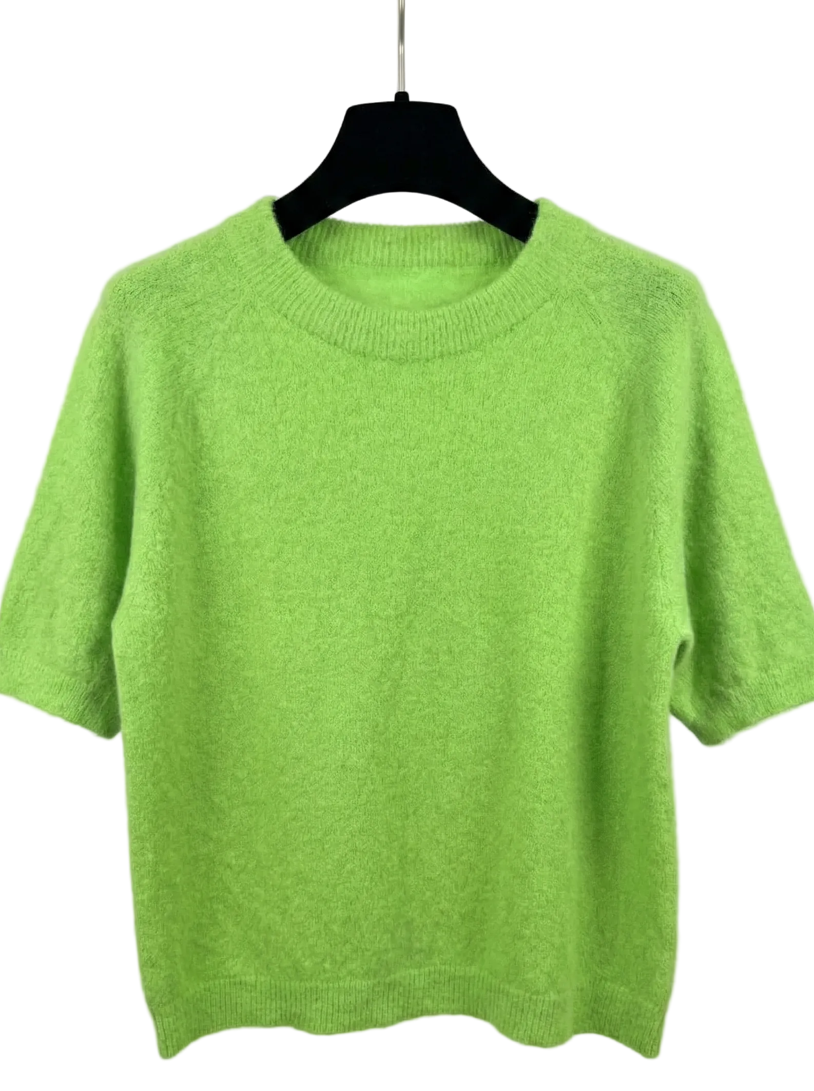 Green sweater on a hanger against a white background