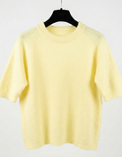 Yellow sweater on a hanger against a white background