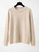 Beige sweater on a hanger against a white background