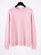 Pink sweater on a hanger against a white background