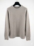 Taupe sweater on a hanger against a white background