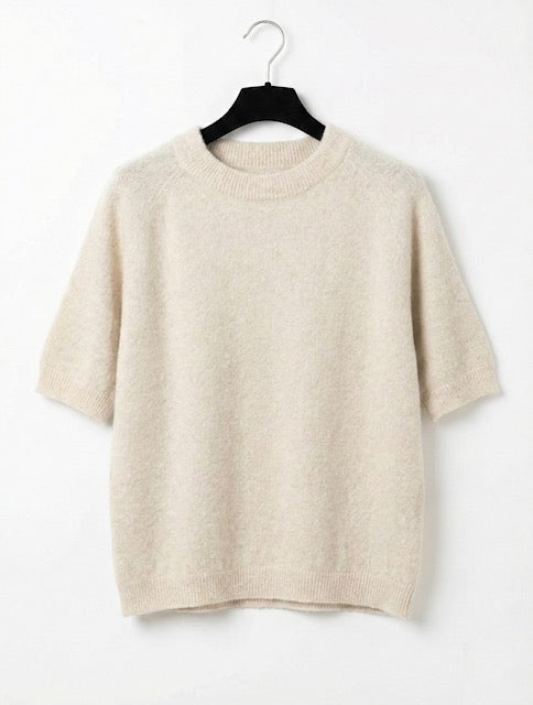 Beige sweater on a hanger against a white background