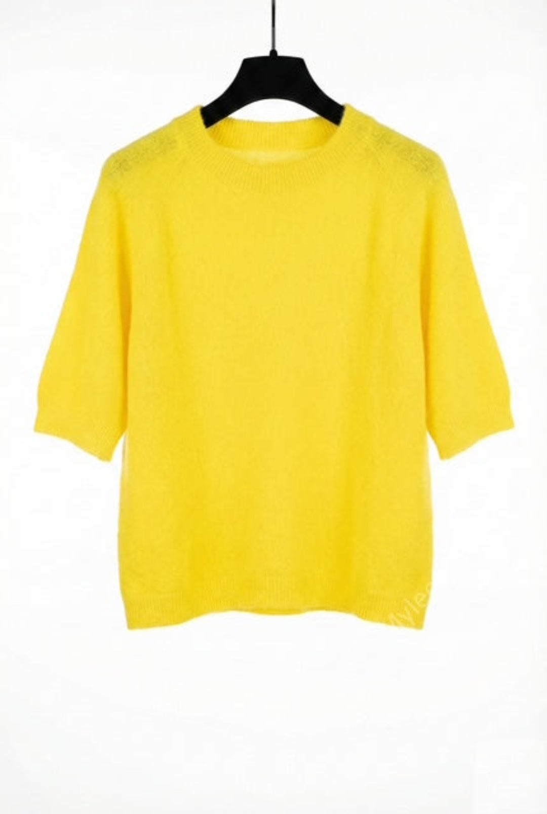 Yellow sweater on a black hanger against a white background