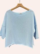 Light blue sweater on a hanger with 'nais' brand visible
