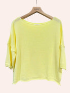 Yellow knit top on a hanger with 'nails' brand visible