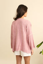 Woman wearing a pink linen jacket on a beige background