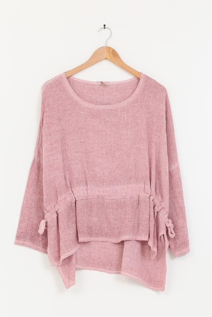 Pink sweater with a belt on a wooden hanger against a white background