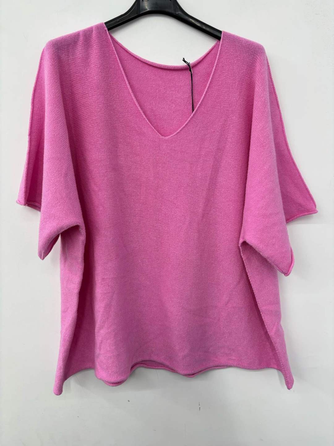 Pink sweater on a hanger against a white background