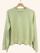 Light green sweater on a hanger