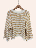 Striped sweater on a hanger against a plain background