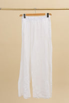 White pants hanging on a beige background