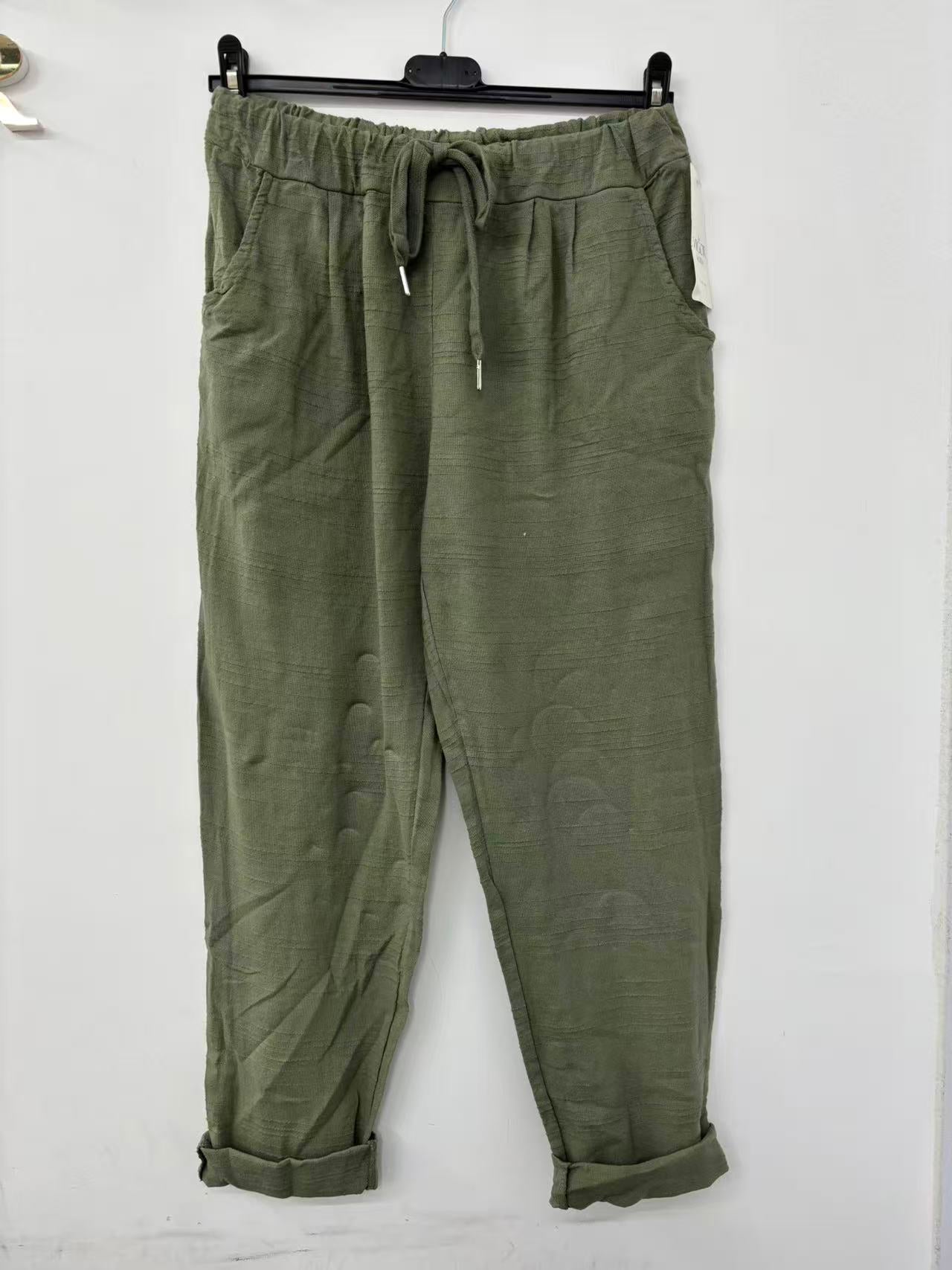 Green pants hanging on a white background