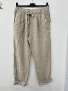 Beige pants on a hanger against a white background
