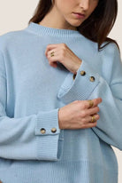 Light blue sweater with button details worn by a person