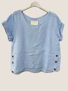 Blue cotton gauze top with button details on a white background