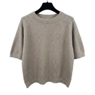 Beige sweater on a hanger against a white background