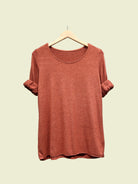 Rust top on a hanger against a plain background