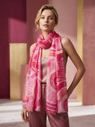 Woman wearing a pink patterned scarf in a studio setting