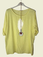 Yellow shirt on a hanger with a necklace 