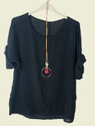 Black top with a necklace on a white background