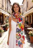 Woman wearing a colorful heart-patterned scarf in an outdoor setting