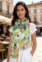 Woman wearing a colorful scarf with heart patterns in an outdoor setting.